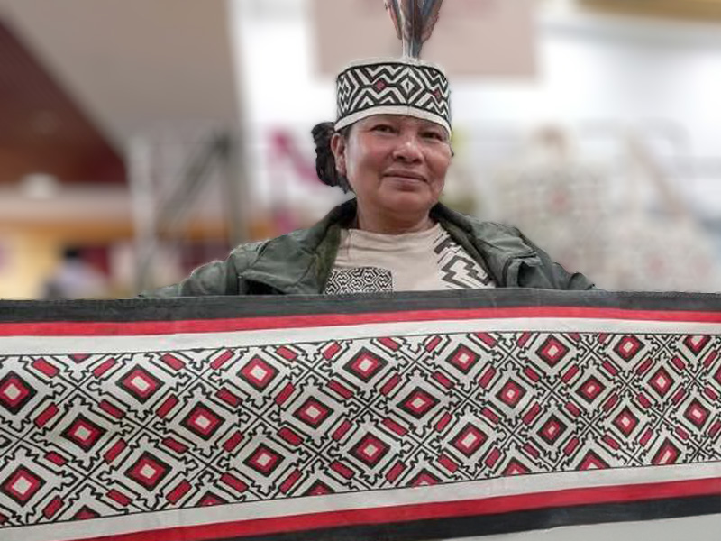 Salomé Sebastián Vargas artesana textil de la comunidad Yine muestra una pieza textil decorada con motivos tradicionales