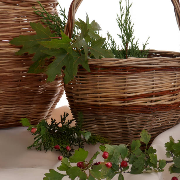 vista parcial de dos cestos de mimbre de varios colores decorados con vegetación