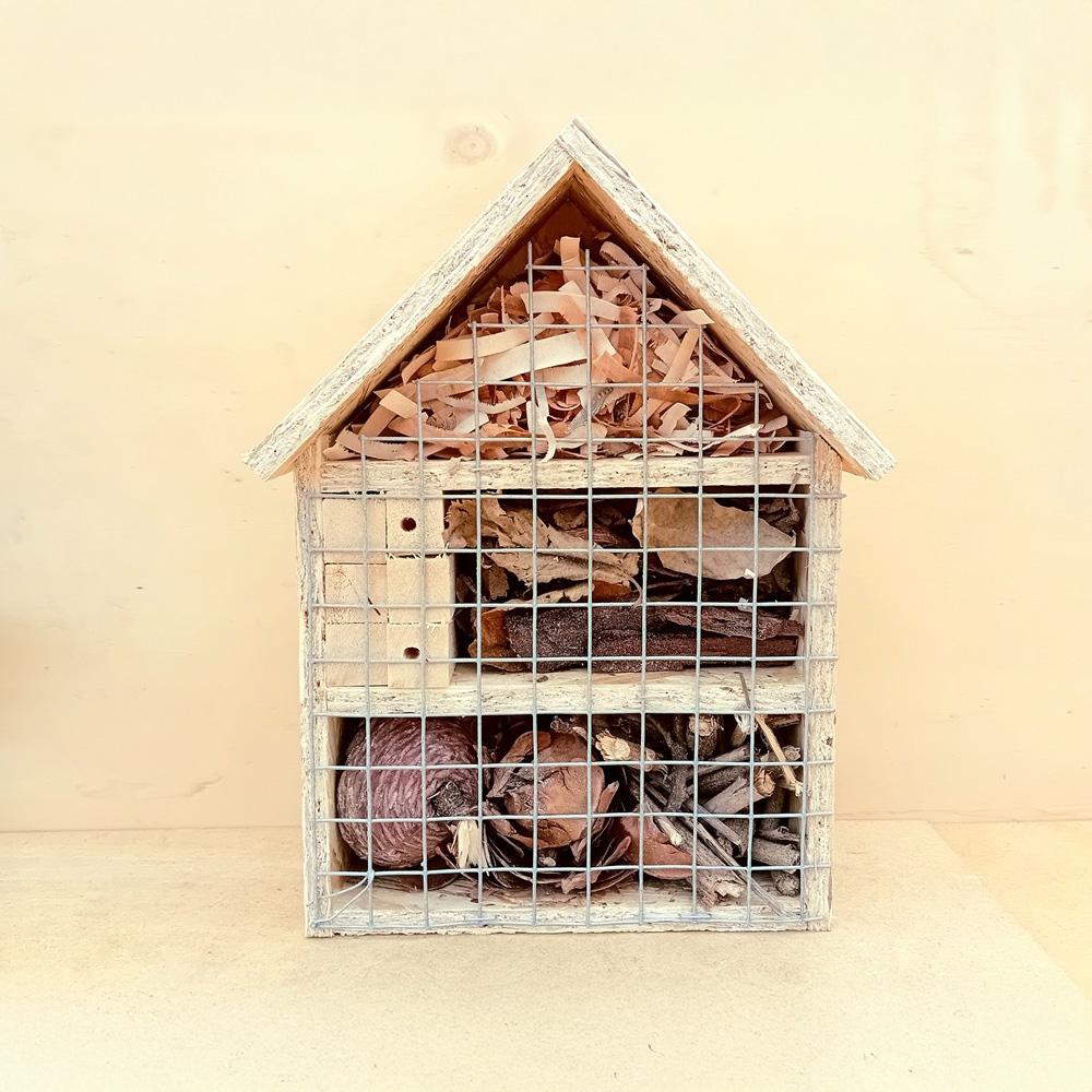 hotel de insectos de tres pisos elaborado en madera con forma de pequeña casa