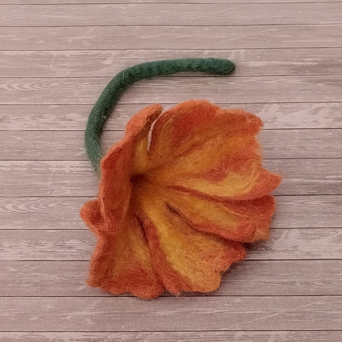 flor naranja con tallo verde de lana fieltrada
