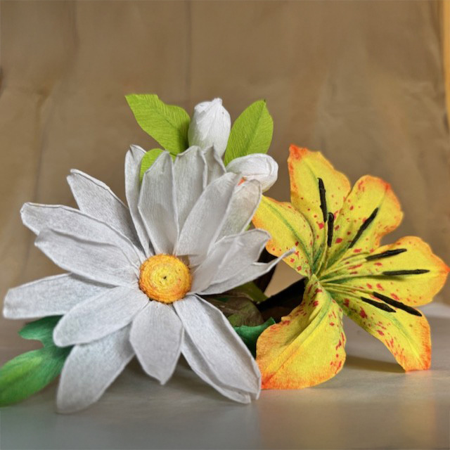 dos flores elaboradas con papel, una blanca y otra amarilla