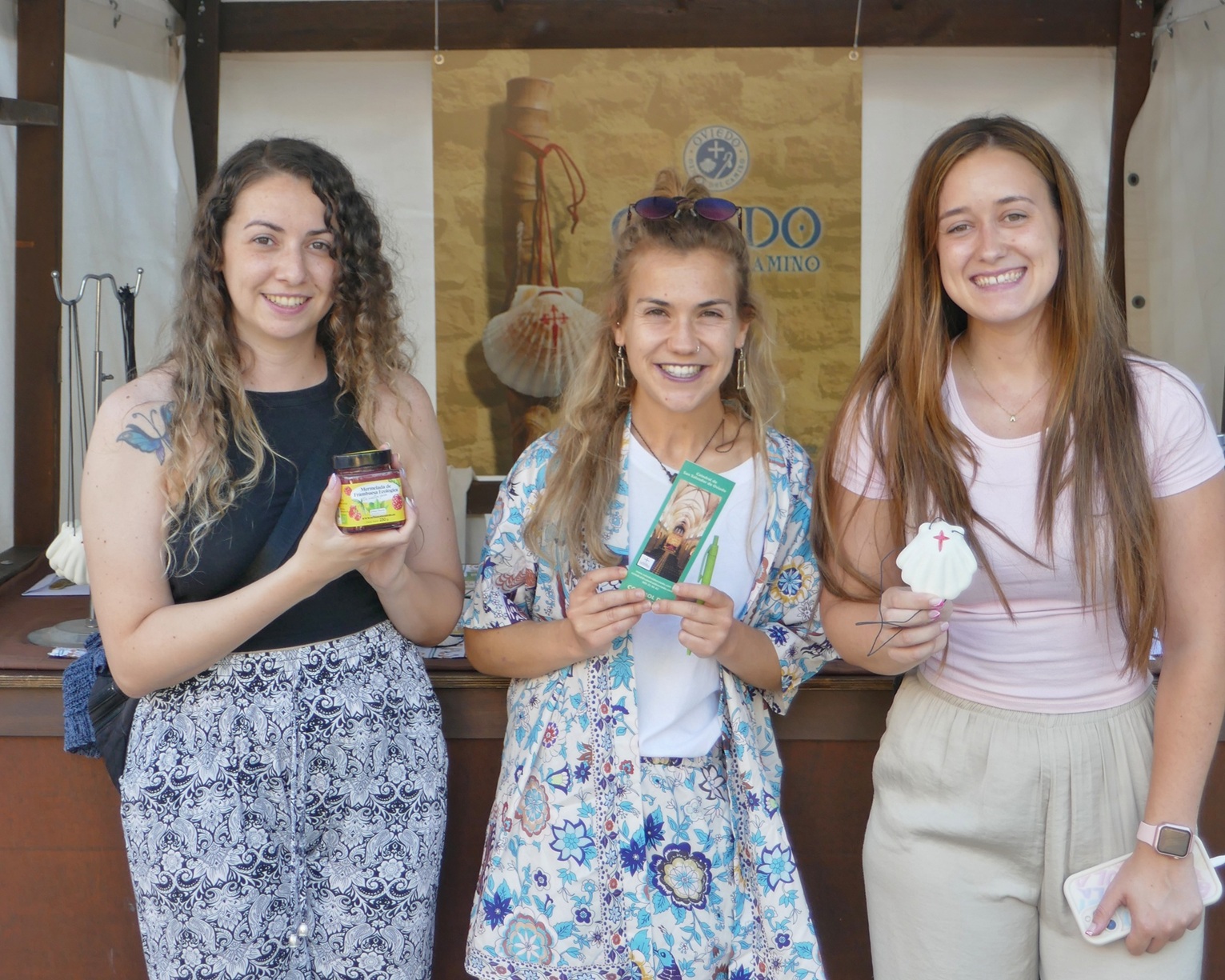 tres mujeres posan frente al puesto del camino primitivo en el mae de Oviedo