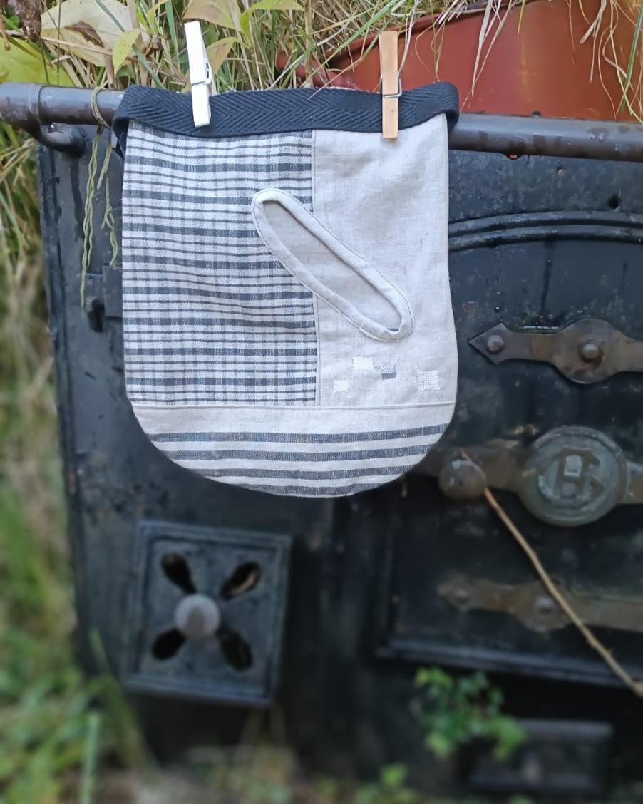 faltriquera suprareciclaje Bolsa de tela artesanal con patrón de rayas colgando con pinzas de ropa.